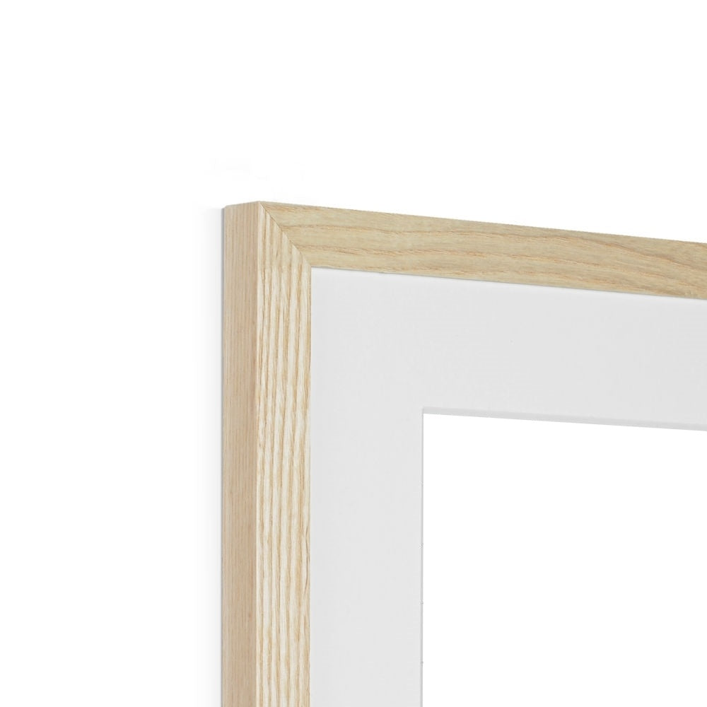 Close up image of a natural wood frame with a white mat.